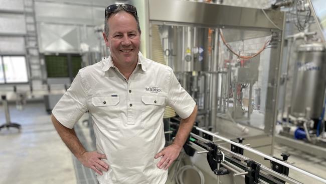 North Queensland Burden Distillery chief executive Tim Lamb shows the new glass bottling line that had been built, which he said was carbon neutral. Picture: Chris Burns.