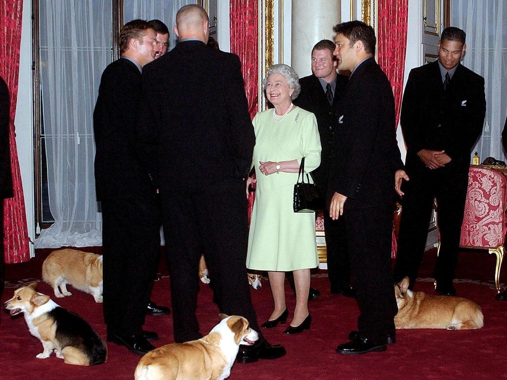 Queen Elizabeth II are accompanied with her corgis, while meeting the New Zealand All Blacks rugby team at Buckingham Palace in 2002. Picture: Kirsty Wigglesworth/ PA Pool/ AFP