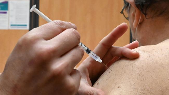 A nurse administers an injection of COVID-19 vaccine to a patient.