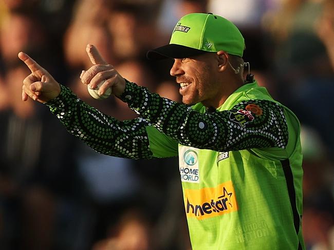 CANBERRA, AUSTRALIA - JANUARY 19: David Warner of the Thunder celebrates taking a catch to dismiss Jake Fraser-McGurk of the Renegades during the Men's Big Bash League match between the Sydney Thunder and the Melbourne Renegades at Manuka Oval, on January 19, 2023, in Canberra, Australia. (Photo by Mark Metcalfe/Getty Images)