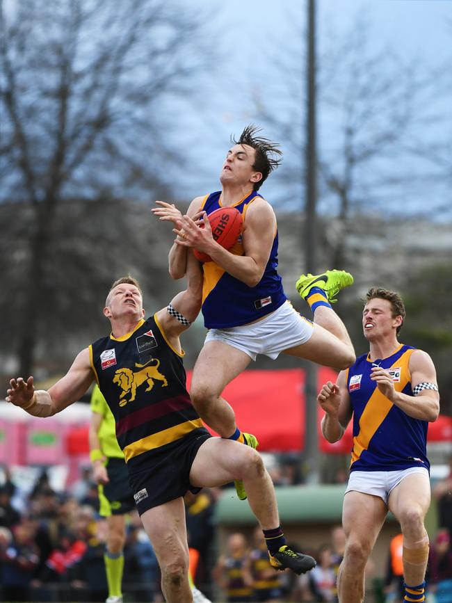 Brendon Droessler of Lilydale (centre) takes a mark.