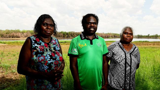 Mirarr traditional owners Yvonne Margarula and Nida Mangarnbarr hold up the judgment documents with a next generation traditional owner Simon Mudjandi following Friday's Jabiru Township Native Title determination in Jabiru, NT. Picture: Justin Kennedy