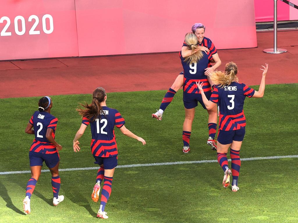 Megan Rapinoe is embraced by her teammates after opening the scoring. (Photo by Atsushi Tomura/Getty Images)