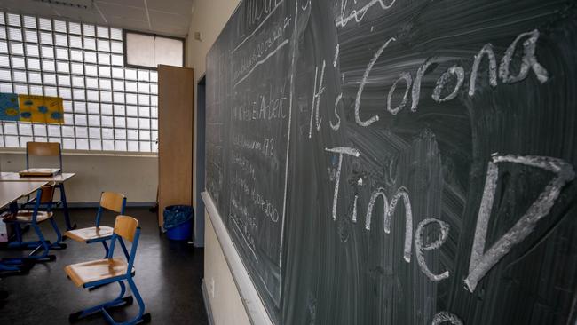 "It's Corona Time" has been written on the blackboard of a now-empty classroom of a high school in Frankfurt, Germany. Picture: Michael Probst/AP