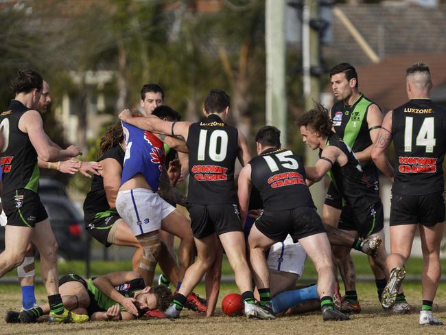 Doveton coach Michael Cardamone lays on the ground after being crunched in a marking contest. Picture: Valeriu Campan