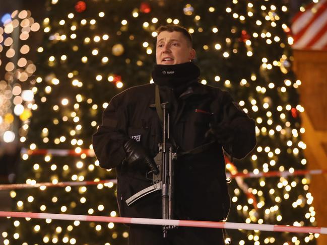 A policeman with a submachine gun stands at the area after a lorry truck ploughed through a Christmas market on December 19, 2016 in Berlin, Germany. Picture: Getty