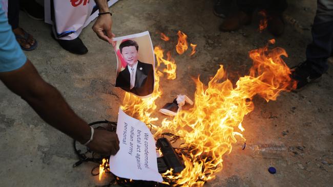 An Indian man burns a photograph of Chinese president Xi Jinping during a protest against China in Ahmedabad. Picture: AP