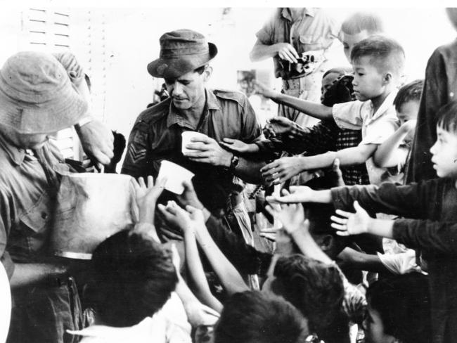 Australian soldiers hand out supplies to Vietnamese children. Picture: AAP-AP