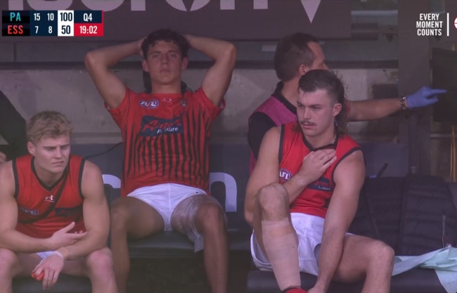 Jye Caldwell and Sam Draper sit on the Essendon bench on ice.