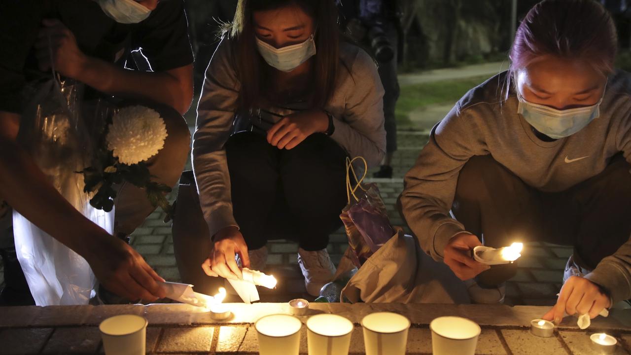 Protesters light candles to pay homage to Chow Tsz-Lok in Hong Kong. Picture: AP