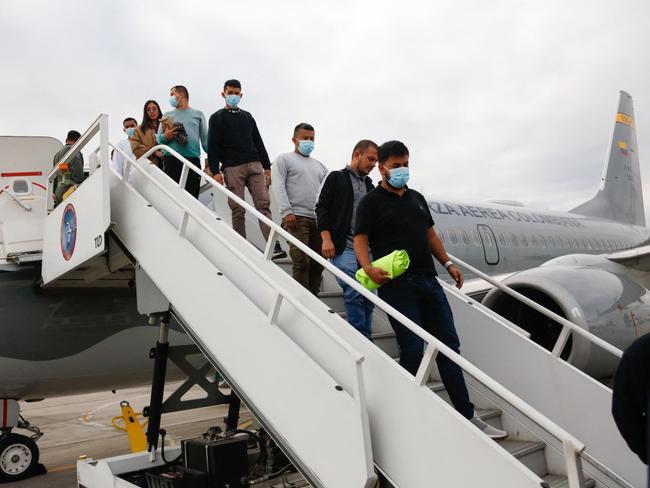 Handout picture released by Colombian Foreign Affairs Ministry press office, shows Migrants descending from a Colombian Air Force plane after being deported from the US  in Bogota on January 28, 2025. Two Colombian military planes with some 200 nationals expelled from the US arrived in Bogota after a blazing row with Donald Trump over migrant deportations, Colombia's President Gustavo Petro said. (Photo by HANDOUT / Colombian Ministry of Foreign Affairs / AFP) / RESTRICTED TO EDITORIAL USE - MANDATORY CREDIT "AFP PHOTO / Colombian Foreing Affairs Ministry / HANDOUT /  " - NO MARKETING NO ADVERTISING CAMPAIGNS - DISTRIBUTED AS A SERVICE TO CLIENTS