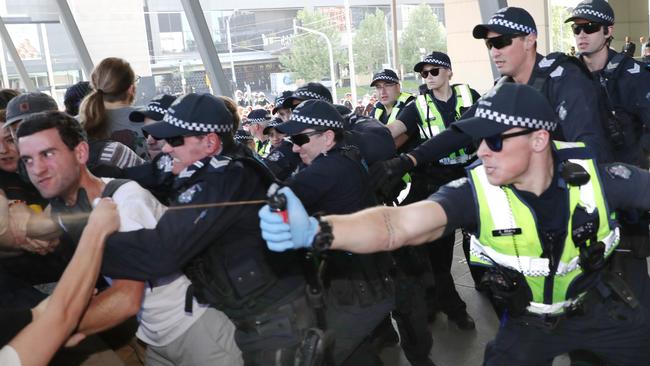 Police use pepper spray as protesters attempt to stop conference members entering during a protest. (AAP Image/David Crosling)