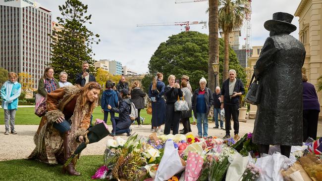 Mourners place bouquets of flowers at the statue of Elizabeth II at Government House, Adelaide. Picture: Matt Loxton