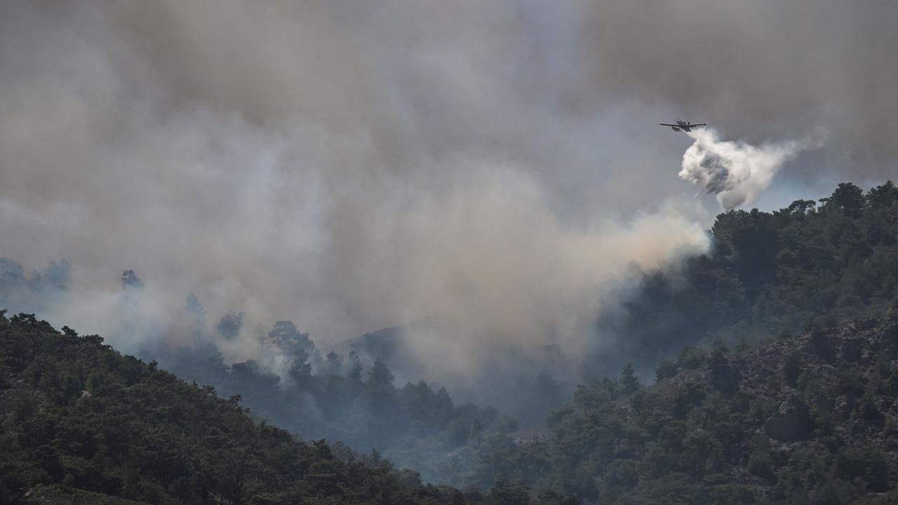 Small planes spray water over a fire between the villages of Kiotari and Gennadi, on the Greek island of Rhodes on July 24, 2023. Picture: AFP.