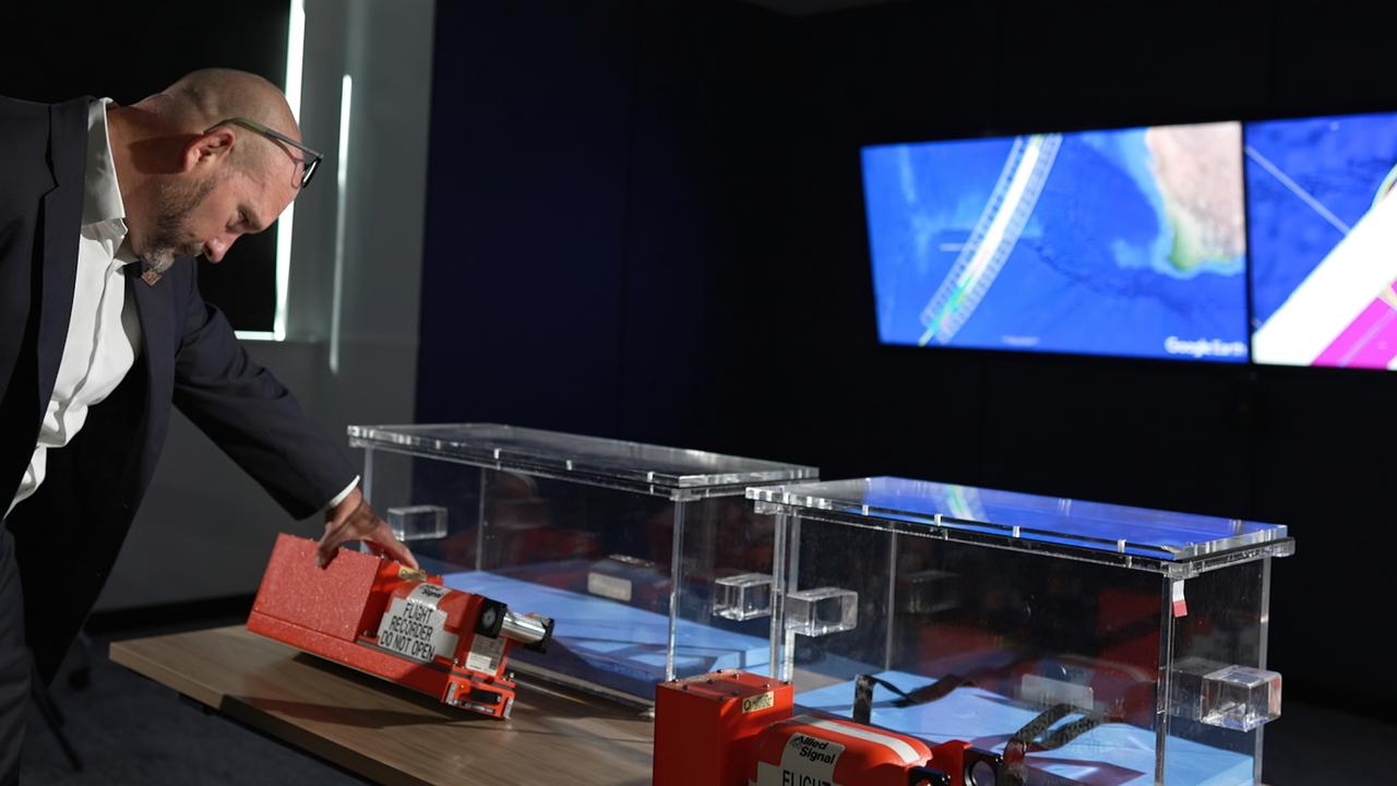 ATSB Chief Commissioner Angus Mitchell with empty boxes that were built to house the flight data recorder and the cockpit voice recorder from the MH370 aircraft when it is found. Picture: Sky News