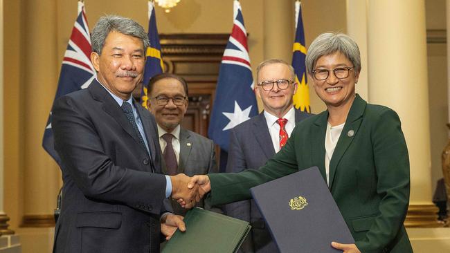 ASEAN summit shows Anwar Ibrahim (2nd L), Anthony Albanese (2nd R) oversee the exchange of the Memorandum of Understanding by Foreign Minister Penny Wong (R) and Malaysia’s Foreign Minister Mohamad Hasan (L).