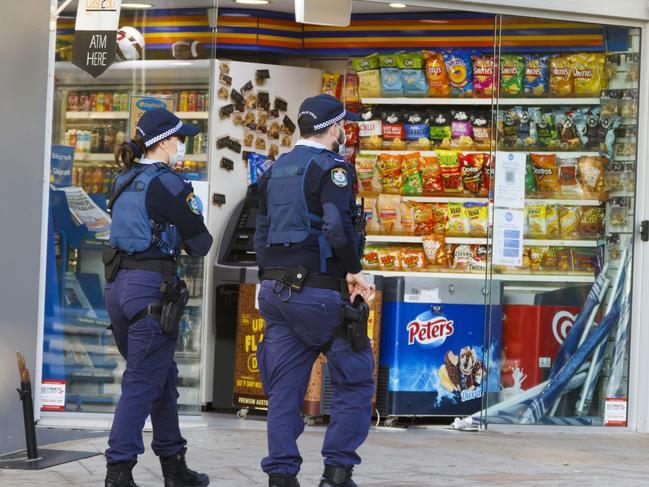 SYDNEY, AUSTRALIA - JULY 22: Police officers walk past a shop at Bronte Beach on July 22, 2021 in Sydney, Australia. Lockdown restrictions have been further tightened as NSW continues to record new community COVID-19 cases and work to stop the spread of the highly infectious delta coronavirus strain in the community. New rules which came into effect at midnight on Saturday across Greater Sydney including the Central Coast, Blue Mountains, Wollongong and Shellharbour require all non-essential retail to close. Businesses can still operate click and collect, takeaway and home delivery. In addition to stay at home orders, residents in the local government areas of  Fairfield, Canterbury-Bankstown and Liverpool cannot leave their areas for work except for emergency services and healthcare workers. Where those workers do need to leave their local government area for work, they are required to be tested every three days, even if they do not have symptoms. Residents of Greater Sydney, the Blue Mountains, the Central Coast and Wollongong are subject to stay-at-home orders with people are only permitted to leave their homes for essential reasons. Essential reasons include purchasing essential goods, accessing or providing care or healthcare, essential work, education or exercise. Exercise is restricted to within the local government area and no further than 10km from home and with a maximum of two people per group. Browsing in shops is prohibited and only one person per household can leave home for shopping per day. Outdoor public gatherings are limited to two people, while funerals are limited to 10 people only. The restrictions are expected to remain in place until 11:59 pm on Friday 30 July. (Photo by Jenny Evans/Getty Images)