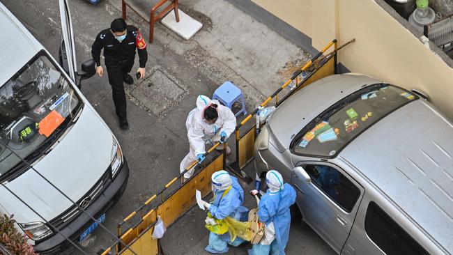 Health workers stand at a check point next to a neighbourhood during a COVID-19 lockdown in the Jing'an district in Shanghai. Picture: AFP.