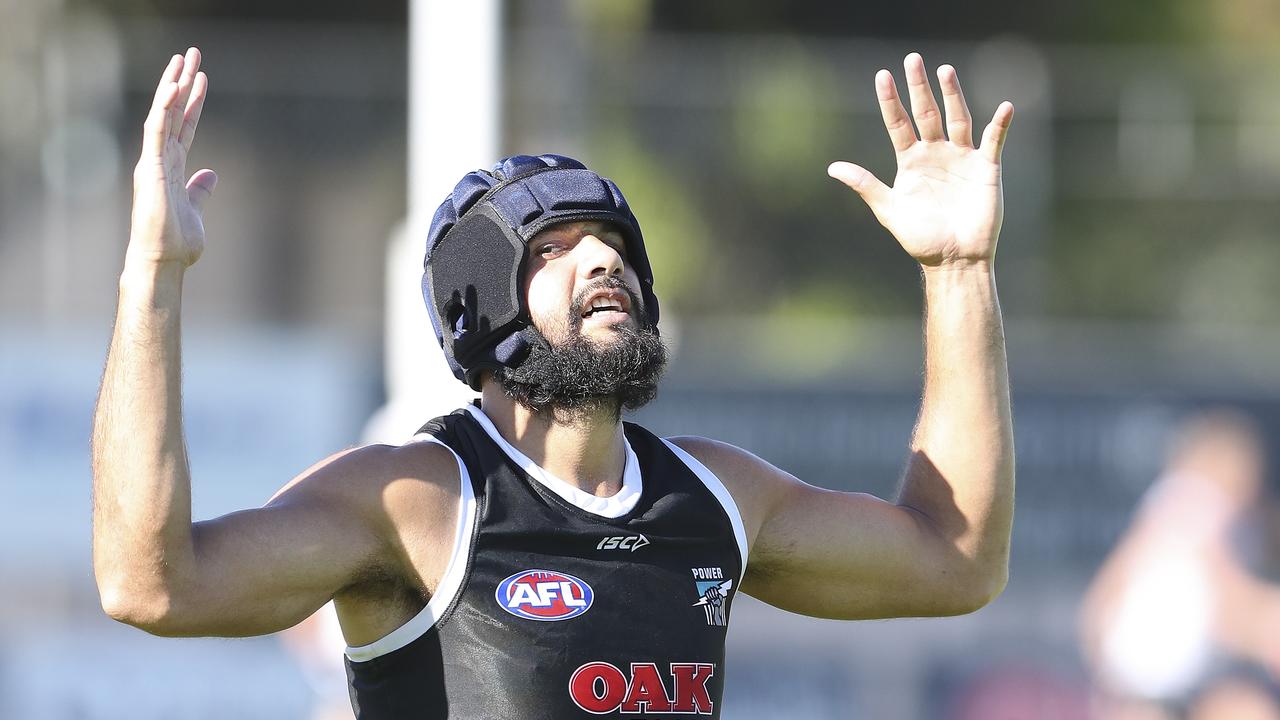 Paddy Ryder tries out a helmet at training on Tuesday to protect his damaged cheekbone. Picture SARAH REED