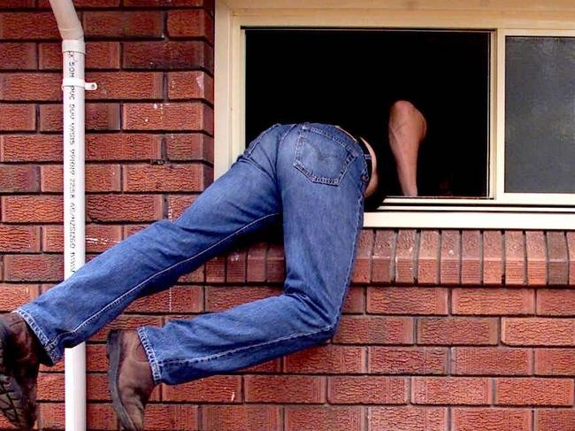 Generic photograph of a burglar thief breaking into a house through an unlocked window. burglary theft larceny. PIRATE: 28/02/2001.