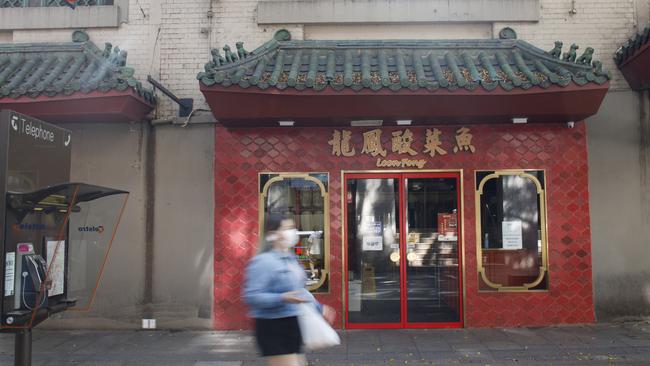 A masked woman cuts a lonely figure in Sydney’s China Town. Normally a hub of activity, it is more like a ghost town as restaurants report a downturn in business as a result of the coronavirus crisis. Picture: Tim Pascoe