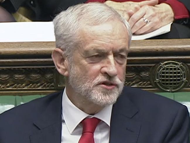 In this House of Commons TV handout video Labour leader Jeremy Corbyn says something under his breath after the British Prime Minister Theresa May likened Labour's attempt to table a no confidence motion in her to a pantomime, during the weekly Prime Minister's Questions in the House of Commons, London, Wednesday Dec. 19, 2018.  With 100 days until Britain leaves the European Union, the government was publishing long-awaited plans Wednesday for a post-Brexit immigration system that will end free movement of EU citizens to the U.K. (House of Commons/via AP)