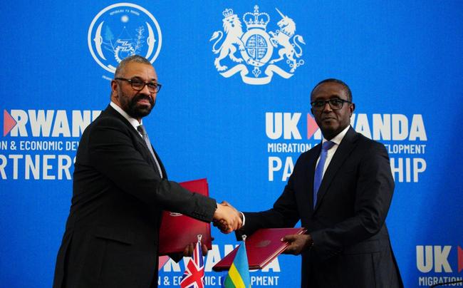 Rwandan Foreign Minister Vincent Biruta (R) signed a new treaty on migrants with his UK counterpart James Cleverly (L) on Tuesday