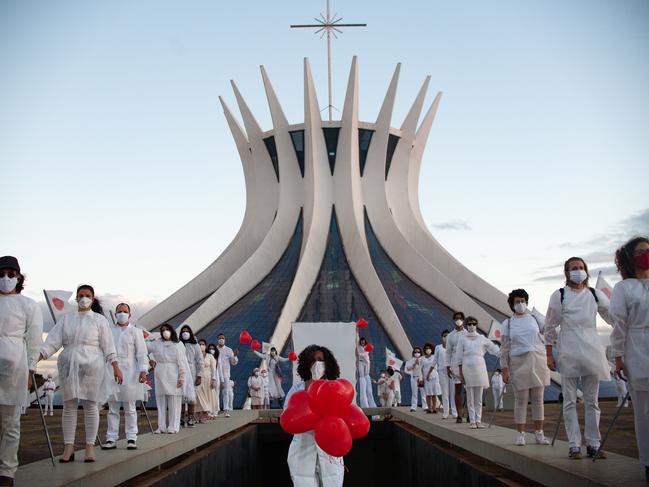 A person holds red balloons during a tribute in Brasilia to victims of COVID-19. Picture: Getty