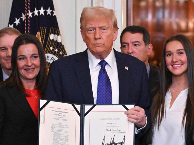 US President Donald Trump poses after signing the Laken Riley Act in the East Room of the White House in Washington, DC, January 29, 2025. The Laken Riley Act -- which mandates the detention of undocumented immigrants charged with theft-related crimes -- is named for a 22-year-old student murdered by a Venezuelan man with no papers who was wanted for shoplifting. (Photo by ROBERTO SCHMIDT / AFP)