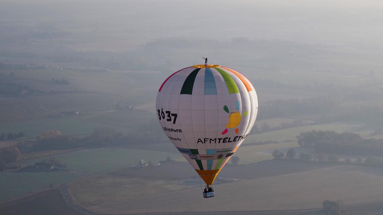 Remi Ouvrard stands on top of the hot-air balloon during his world record ride above western France. Picture: AFP