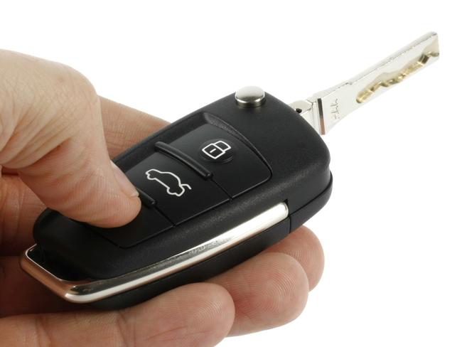Car key with remote control on hand. Generic image.