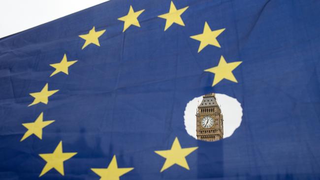 A pro-remain protester holds up an EU flag with one of the stars symbolically cut out in front of the Houses of Parliament in 2017. Picture: AFP