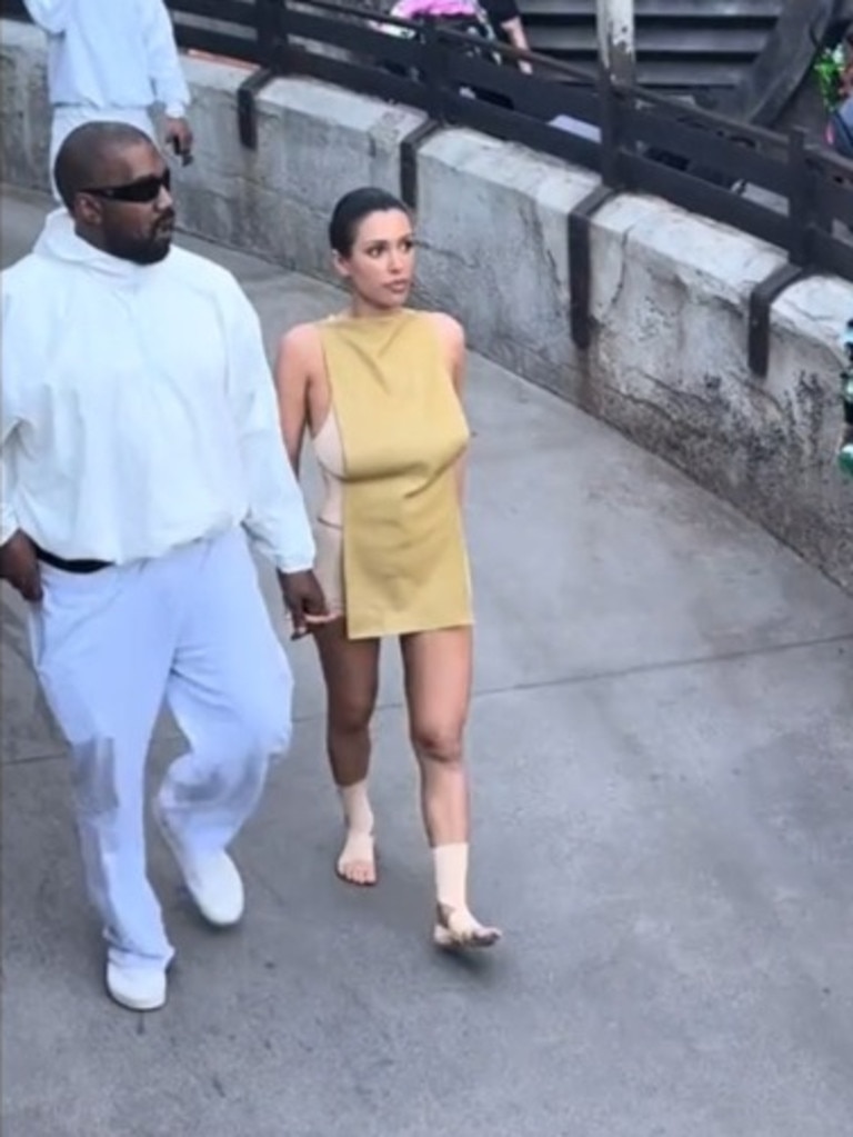 Kanye West and Bianca Censori walk through Disneyland.