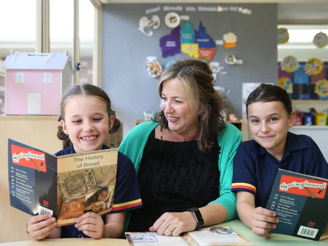 St Hilda's has eleven students to every one teacher, one of the lowest ratios on the Gold Coast. Year two students Charli Knight 8 and Sophie Cox 8 reading with teacher  Marina Jacovou-Johnson. Picture Glenn Hampson