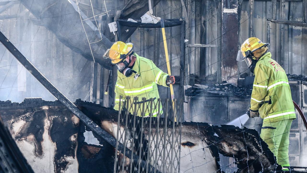 NTFES Firegighters douse the remaining smouldering ruins of a Business Fire overnight Picture: Glenn Campbell