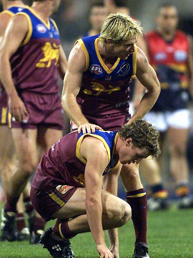 Jason Akermanis checks on Luke Power after a big hit in the loss to Adelaide.