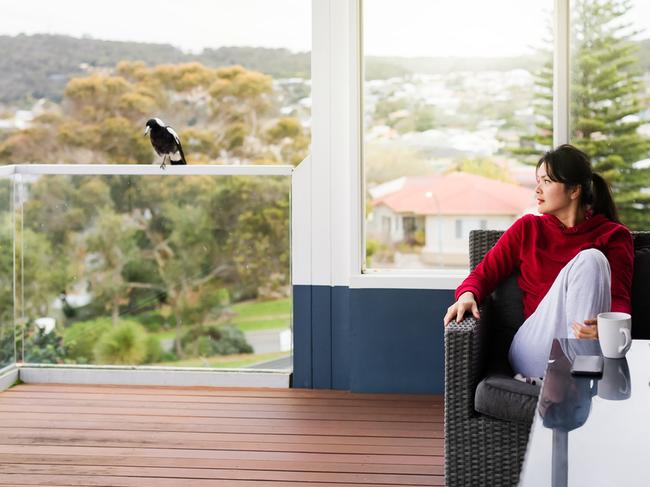 woman watching bird in balcony