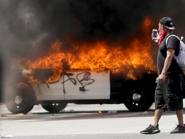 An LAPD vehicle burns after being set alight by protesters. Picture: Getty Images