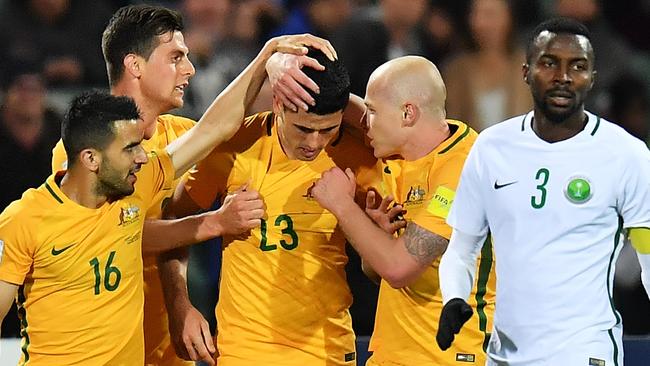 Socceroos players celebrate with Tom Rogic (centre) after he scored the winning goal against Saudi Arabia on Thursday night.