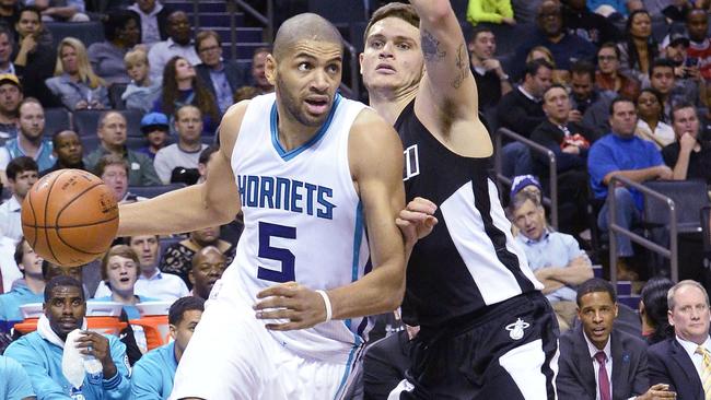 Charlotte Hornets guard Nicolas Batum, left, drives the ball to the basket against Miami Heat's Tyler Johnson.