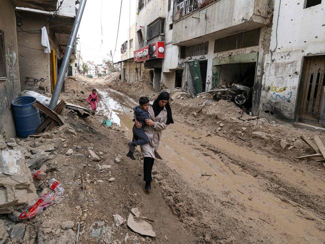 A Palestinian woman carries her child after an Israeli military operation in the Jenin refugee camp in the Israeli-occupied West Bank. Picture: AFP