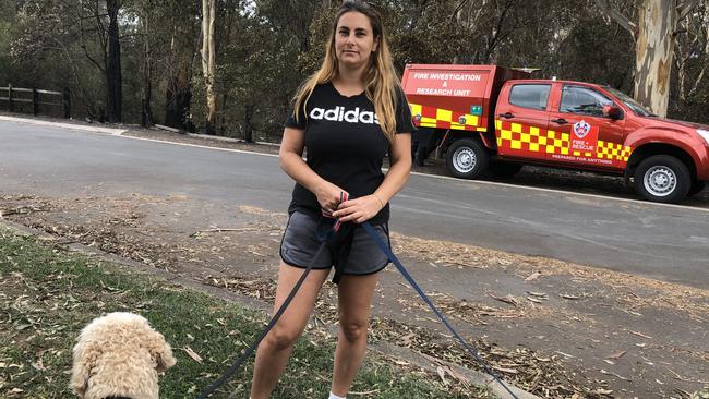 Resident Vicki Lazos walks her dogs a day after the fire at Whitehaven Rd.