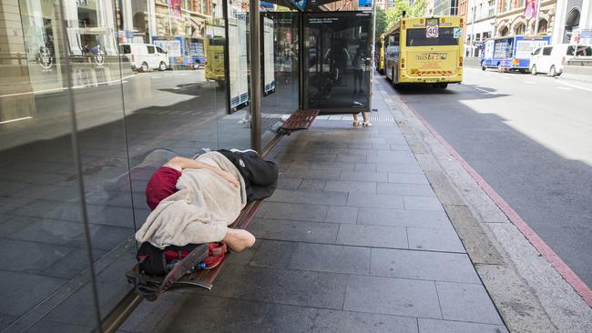 A homeless man sleeps on the QVB Bus on York Street. Picture: Dylan Robinson