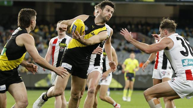 MELBOURNE, AUSTRALIA - JUNE 25: Trent Cotchin of the Tigers handballs during the round 15 AFL match between the Richmond Tigers and the St Kilda Saints at Melbourne Cricket Ground on June 25, 2021 in Melbourne, Australia. (Photo by Darrian Traynor/Getty Images)