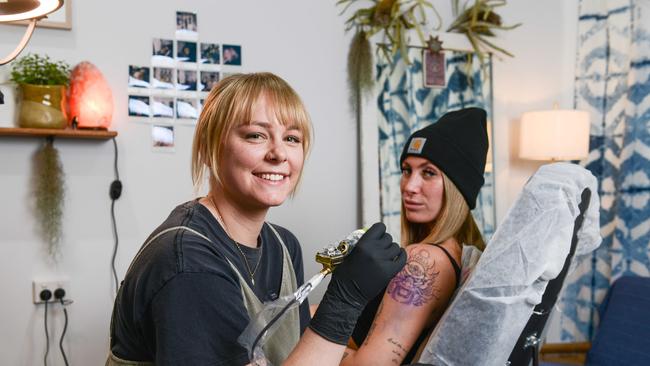 Caitlin at her studio in 2021. The tattoo artist manages to fit touring into her busy schedule – with her art in hot demand. Picture: Brenton Edwards