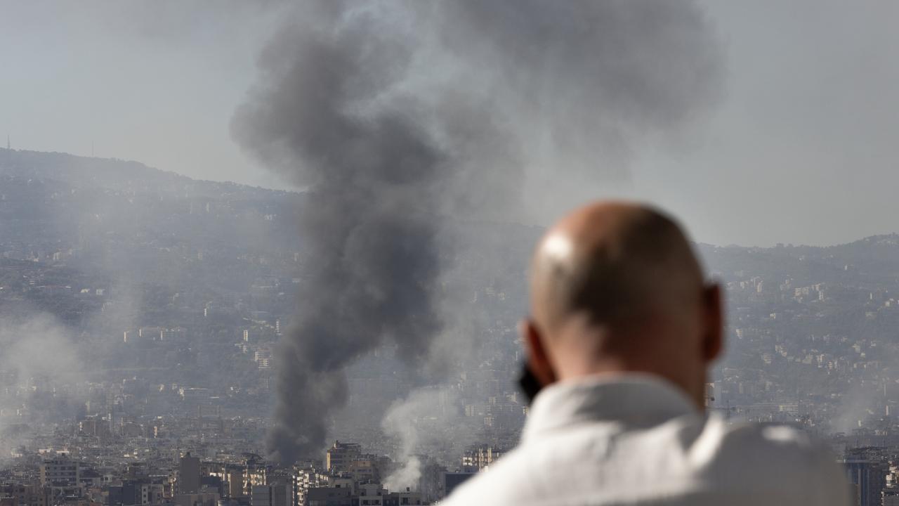 A man watches as smoke plumes rise over the city after Israeli forces conducted multiple air strikes on the city's southern suburbs on October 3, 2024 in Beirut, Lebanon. (Photo by Daniel Carde/Getty Images)