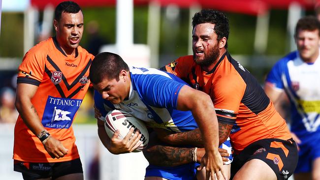 Action from the Bycroft Cup rugby league grand final match between the Tugun Seahawks (blue) and the Southport Tigers (orange). Tugun's Bodie Clark is tackled by a bloody Marty Mitchell.