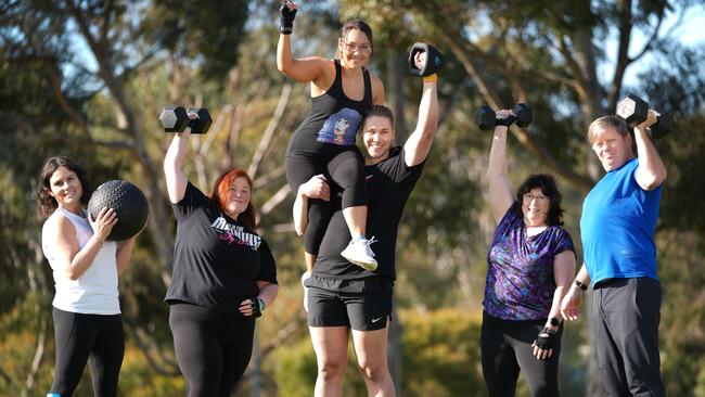 PT Shane Barker with regular clients Brooke Holloway, Jodi Douglas, Kylie Kyriacou, Christine Ruby, and Aaron Posad, who say he goes above and beyond helping them stay fit. Picture: Dean Martin