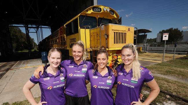 Queendsland Firebirds Tara Hinchliffe, Rudi Ellis, Gretel Bueta &amp; Lara Dunkley in front of an Aurizon train. Pic Peter Wallis