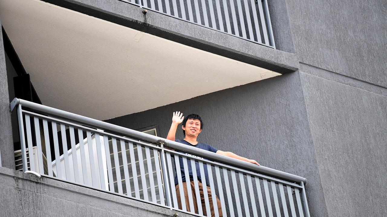 A quarantined guest waves from his balcony at the Hotel Grand Chancellor in Spring Hill, Brisbane. Picture: NCA NewsWire / Dan Peled